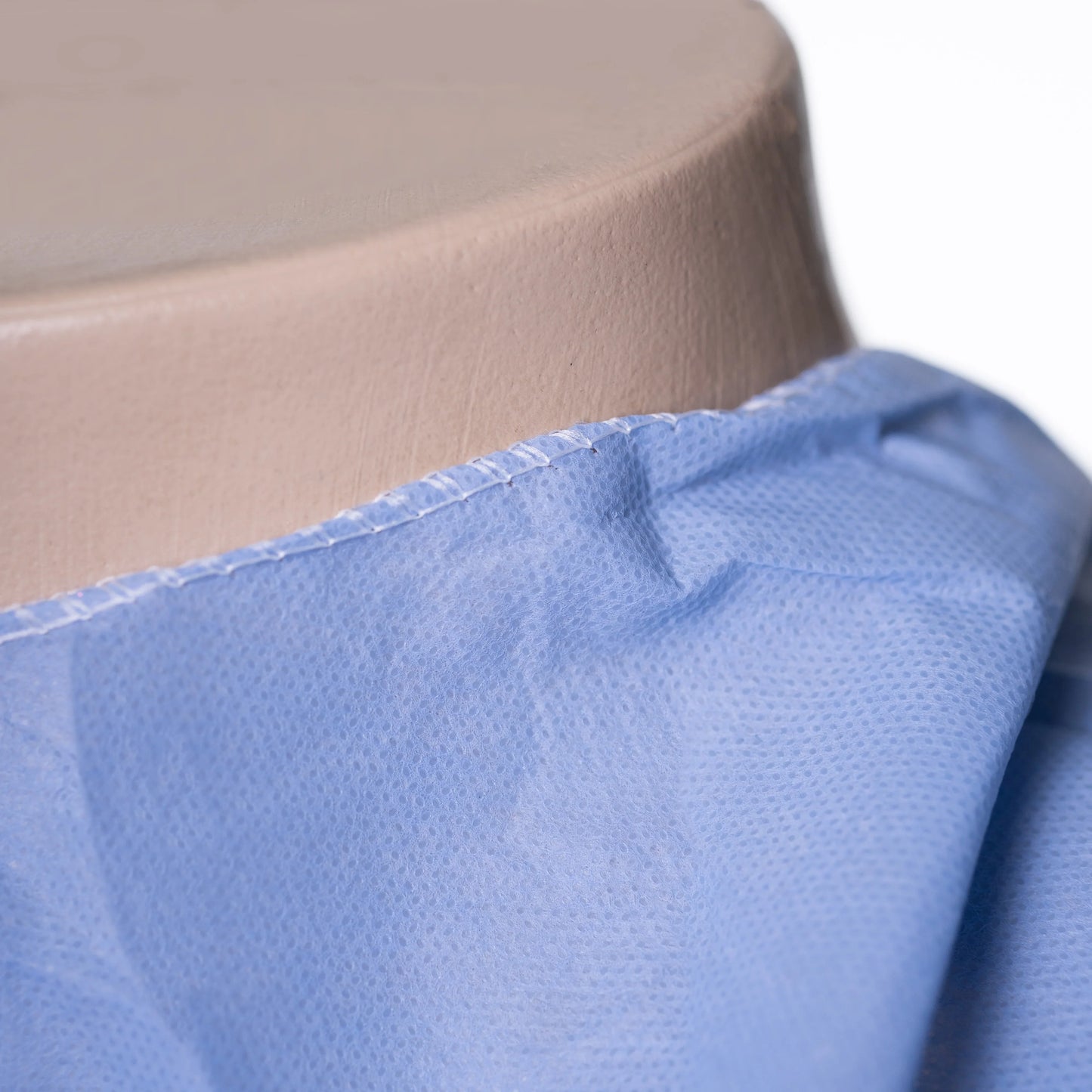 Close-up of blue disposable hospital gown fabric on mannequin neck, MEGA USA medical supply